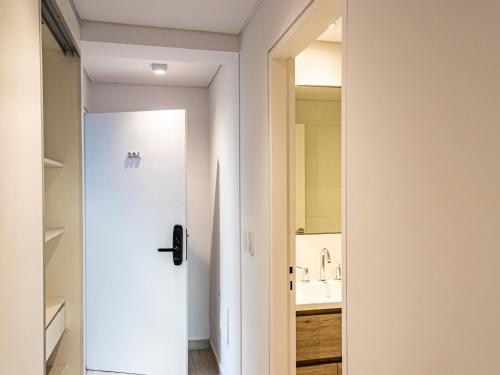 a bathroom with a white door and a sink at Cañada Suites by FMA Coliving in Salta