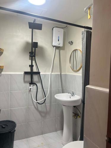 a bathroom with a sink and a toilet and a mirror at Condo at 16th Floor Free Pool Access with Private Balcony in Suba