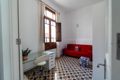 a living room with a red couch and a desk at La Casa del Mar in Garachico