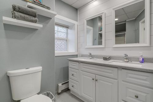 a white bathroom with a toilet and a sink at Downtown Casper Gem! Super Walkable Apartment in Casper
