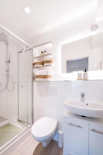 a white bathroom with a toilet and a sink at modernes Apartment bei Schlosspark Nymphenburg, Top Verkehrsanbindungen, free parking, perfekt für Business- City-Trips und Events in Munich