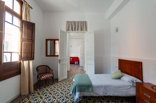 a bedroom with a bed and a chair and a window at La Casa del Mar in Garachico