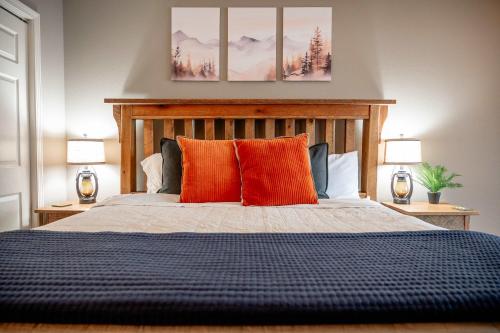 a bedroom with a bed with orange pillows and two lamps at Lakescape at the Getaways in Kimberling City