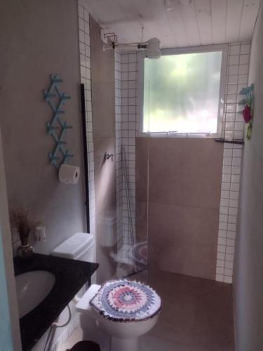 a bathroom with a toilet and a sink and a shower at Chalé Do Lago in Piracaia