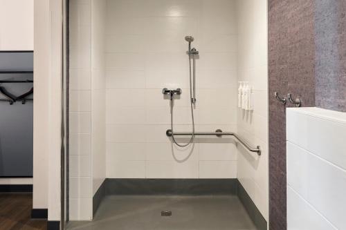 a shower stall in a bathroom with white tiles at Four Points Flex by Sheraton Malaga Centre in Málaga