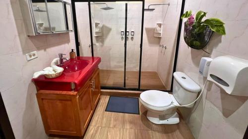 a bathroom with a red sink and a shower at Quinta Sunset, Lago de Coatepeque in El Congo