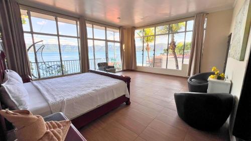 a bedroom with a bed and a view of the ocean at Quinta Sunset, Lago de Coatepeque in El Congo