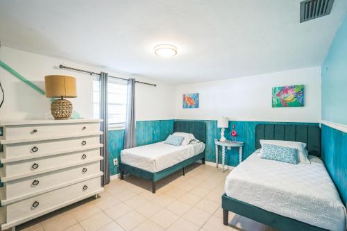 a bedroom with two beds and a dresser at pink peacock in Holmes Beach