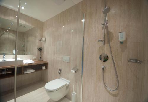 a bathroom with a shower and a toilet and a sink at Cityhotel D&C St.Pölten in Sankt Pölten