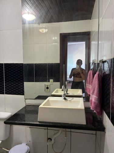 a man taking a picture in a bathroom mirror at Casa com 2 quartos in Cabo Frio