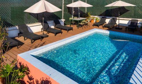 a swimming pool with chairs and a table and umbrellas at TONALA By Mr W in Mexico City