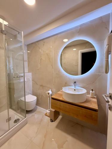 a bathroom with a sink and a toilet and a mirror at Vila Vladorena in Požega