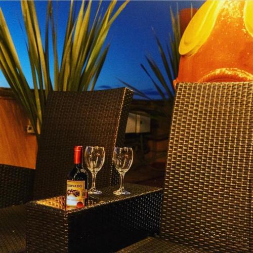 a bottle of wine and two glasses on a table at Casa Rosario Centro in San Miguel de Allende