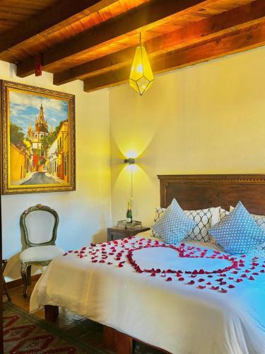 a bedroom with a bed with a red flower on it at Casa Rosario Centro in San Miguel de Allende