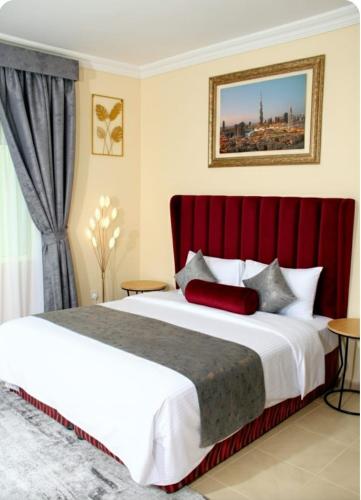 a bedroom with a large bed with a red headboard at BARAKAH HOTEl in Sharjah