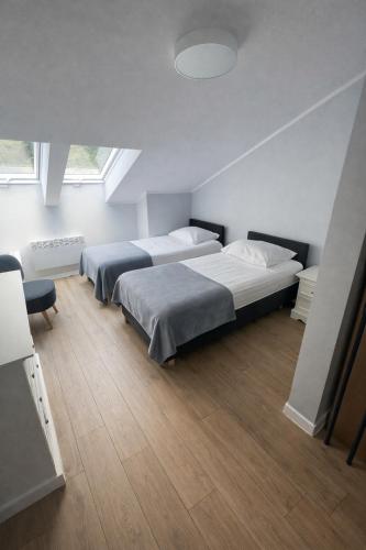two beds in a room with two windows at Ośrodek TVP Sarnówek in Szałkowo