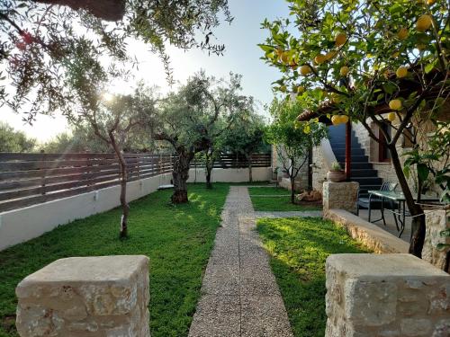 a garden with trees and a walk way at Georges Houses Mani in Riglia