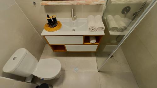 a bathroom with a white toilet and a sink at Lev Yam Suite in Netanya
