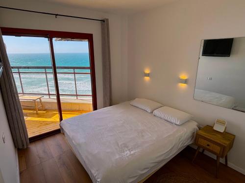 a bedroom with a bed and a view of the ocean at Lev Yam Suite in Netanya