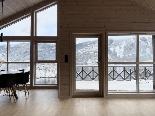 a dining room with large windows and a table and chairs at FjordCabin Preikestolen in Strand