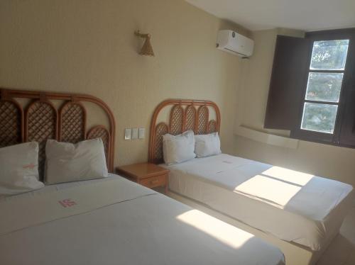 ein Schlafzimmer mit zwei Betten und einem Fenster in der Unterkunft Hotel Santander Veracruz in Veracruz