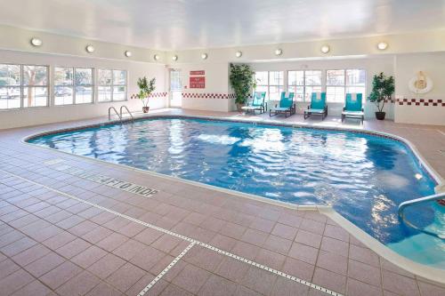 a large swimming pool with blue chairs in a hotel room at Residence Inn by Marriott Waco in Waco