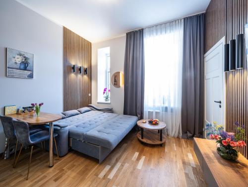 a living room with a blue couch and a table at Premium Design, Renovated 2024 Free parking in Riga