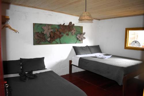 a bedroom with two beds and a painting on the wall at El Hostal del Abuelo in Murillo