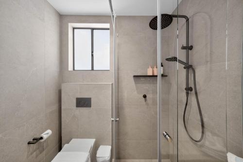 a bathroom with a shower with a toilet and a sink at Bonanza Lane Hideaway in Sydney