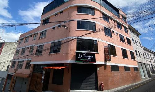 a red brick building with a sign on it at Ukuku Hostel & Rooftop - Quito in Quito