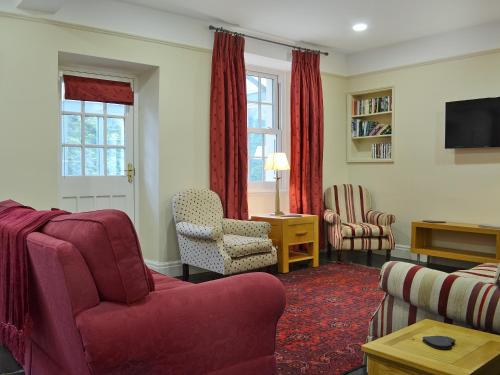a living room with a red couch and chairs at Fellmere in Ambleside