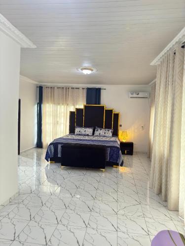 una camera da letto con un letto in una stanza con pavimenti in marmo di Royal Duplex Guest House a Limbe