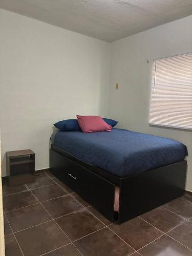 a bedroom with a bed with a red pillow on it at Modern 2-Bedroom House in Guaymas in Guaymas