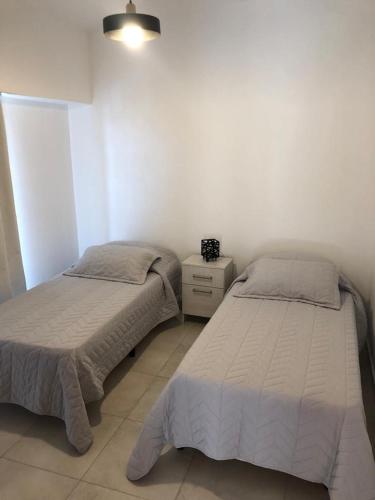 a bedroom with two beds and a night stand at House beach in Puerto Madryn