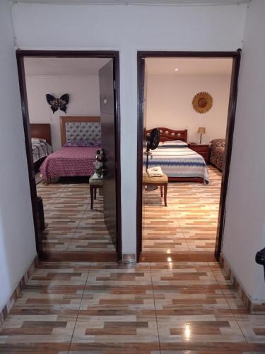 a bedroom with a bed and a mirror at Casa Turistica Andy in Cali