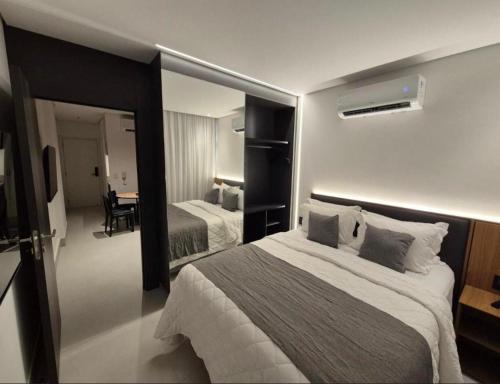 a hotel room with two beds and a mirror at Porto 2 live in Porto De Galinhas
