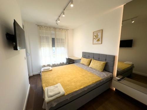 a small bedroom with a bed and a television at I&I Tesla IV in Kragujevac
