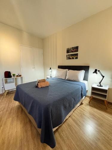 a bedroom with a large bed with a blue blanket at AP Smart Glicério in Campinas