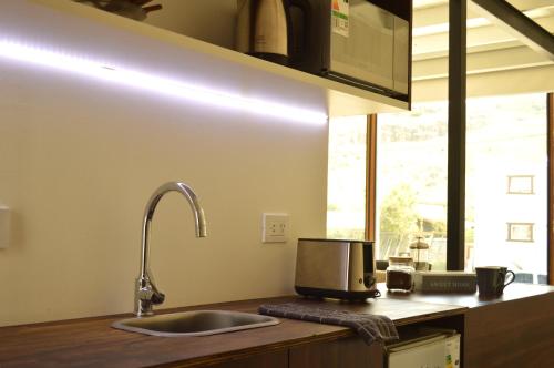 a kitchen with a sink and a microwave at Las Loicas Chalten Apart in El Chalten