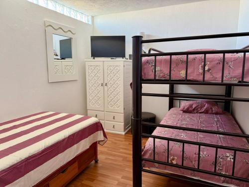 a bedroom with two bunk beds and a television at Departamento acogedor, moderno y céntrico in Apizaco