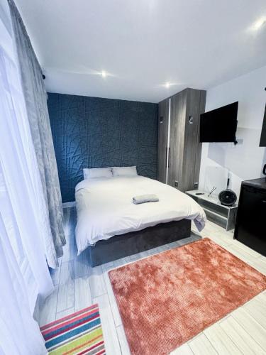 a bedroom with a white bed and a rug at Modern Luxury 2 Bed and Private Studio Room with Parking in Catford