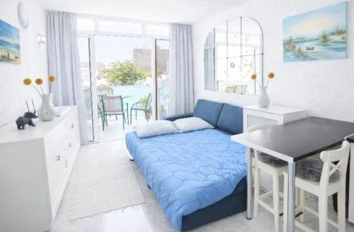 a living room with a blue couch and a table at New Puerto Rico Terrace Swiming Pool in Mogán