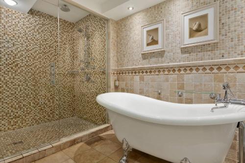 a bathroom with a white tub and a shower at Delta Hotels by Marriott Saint John in Saint John