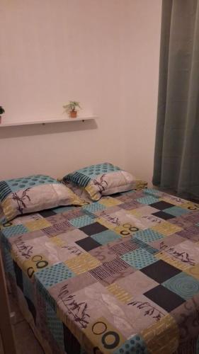 a bed with a quilt on it in a room at Le Lys de la paix in Le Morne Rouge