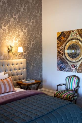 a bedroom with a bed and a chair at St Agnes by Prunella in Kyneton