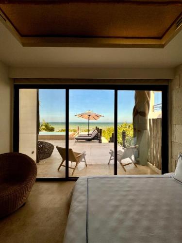 a bedroom with a view of a patio with an umbrella at Beach House Costa Yucatan by Trobbu Collection in Xtampú