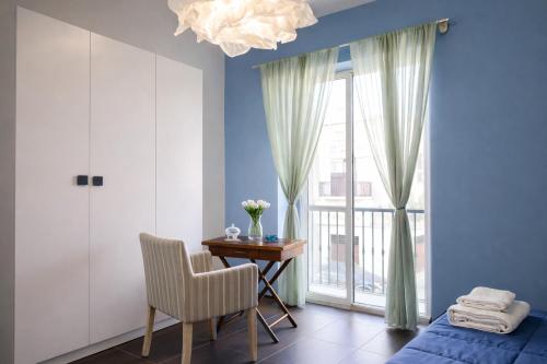 a bedroom with a bed and a desk and a window at Maison Geraldine in Marcianise