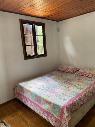 a bedroom with a bed and a window at Chateau Magalhães in Itatiba