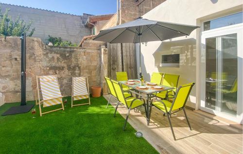 a table and chairs with an umbrella on a lawn at Convent Holiday Home in Petra