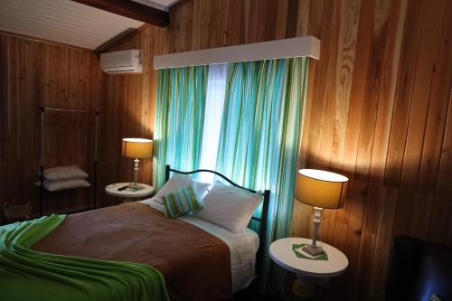 a bedroom with a bed with two lamps and a window at Casa do Calço in Ponta Delgada